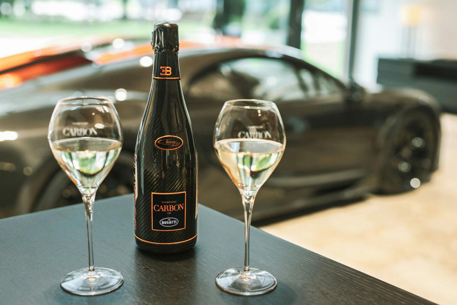 Ein außergewöhnliches Automobil und ein außergewöhnlicher Champagner: der Bugatti Chiron Super Sport 300+ und der Carbon EB.02 Chiron 300+ in der Bugatti Customer Lounge am Stammsitz der Marke in Molsheim.