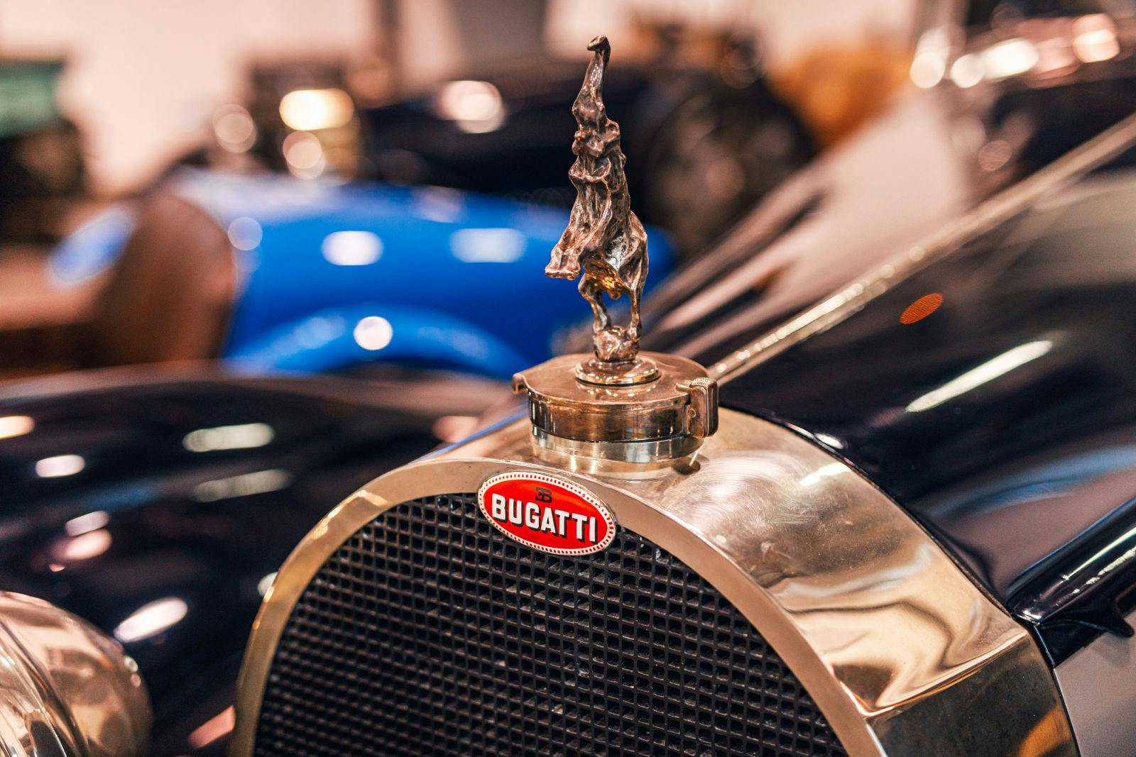 Das Bugatti-Macaron am Bugatti Type 41 Royale zusammen mit der Kühlerfigur eines tanzenden Elefanten als Hommage an Rembrandt Bugatti.