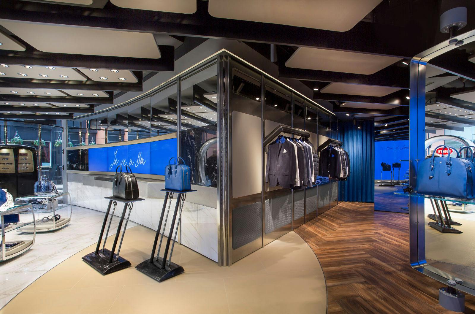 The interior of the boutique is divided into two areas. The EB – Ettore Bugatti Collection is displayed in the luxury/lifestyle area, which is fitted with an elegant dark wooden floor and brown leather wall panelling, both of which exude warmth and elegance. The Bugatti – Performance Luxury Collection is presented in the sports/performance area, which is in sharp contrast with the first area as it features distinctive white marble flooring and light grey leather wall panelling.