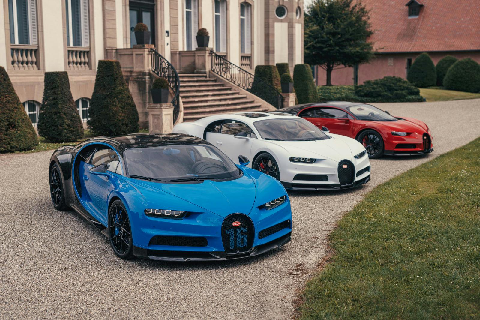 Bugatti célèbre la fête nationale française : trois Chiron Sport devant le Château Saint-Jean à Molsheim.